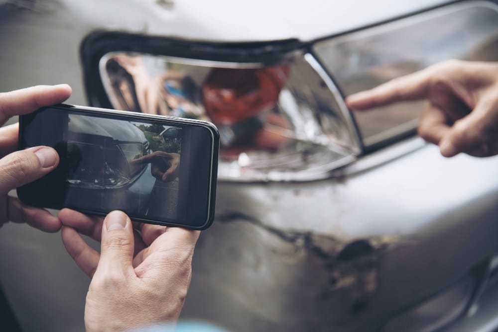 man trying to taking pictures and documenting the scene to prove fault How Do You Prove Fault In a Car Accident Case When Its Your Mistake