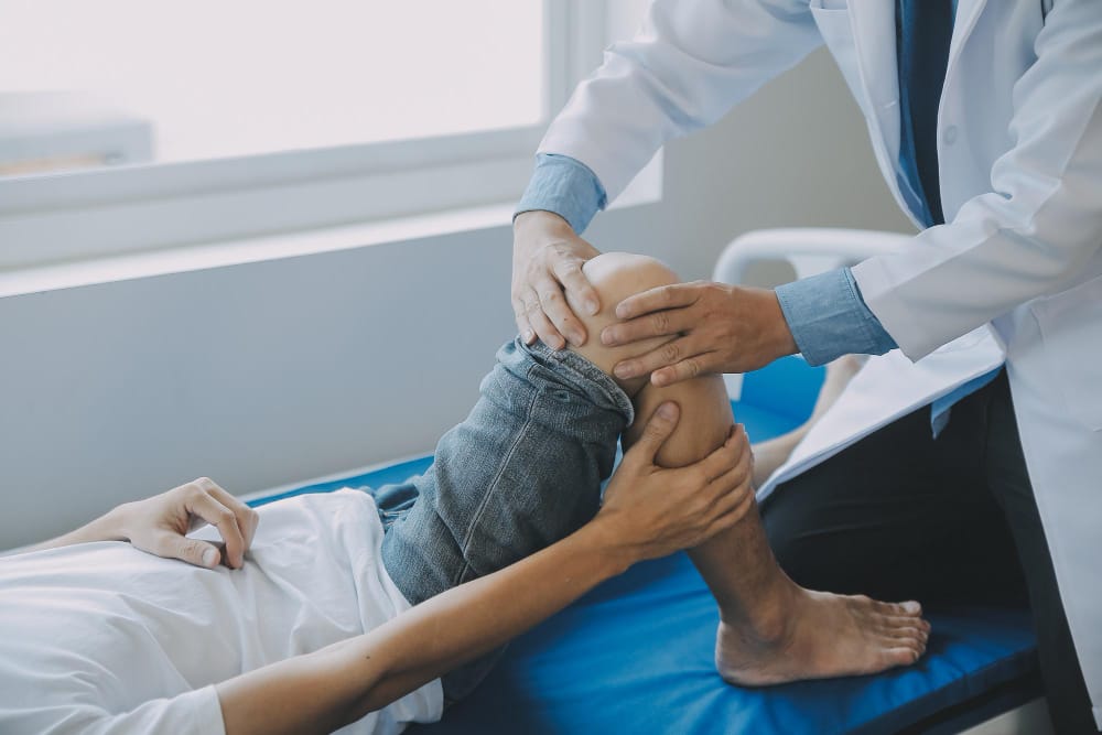  A person holding their injured knee with a concerned expression, representing personal injury.