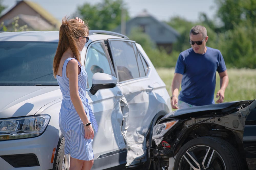 Two vehicles involved in a collision on a city street, with emergency responders assessing the situation