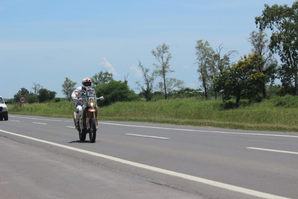 A motorcycle riding between two lanes of cars in heavy traffic.