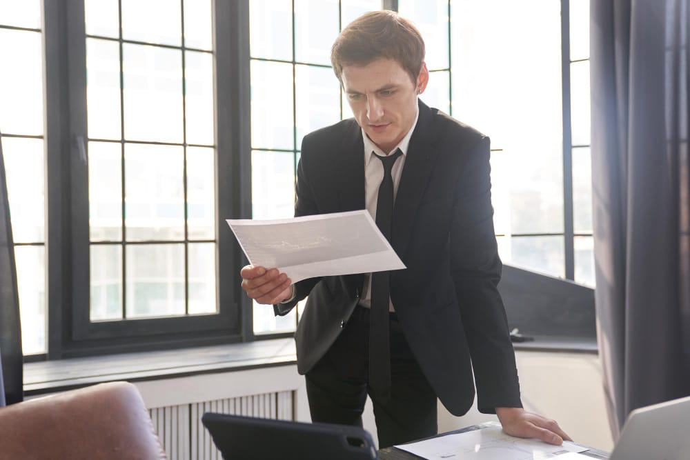 A lawyer reviewing a settlement check with a concerned client in an office setting.