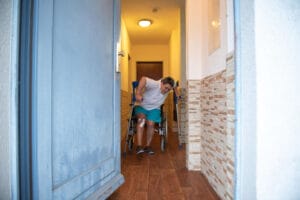 A person making a phone call to report nursing home abuse, with a notebook and pen nearby.